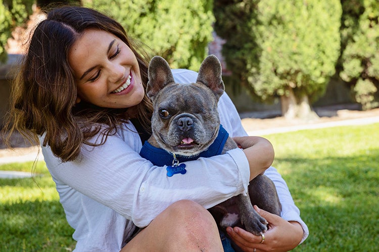 Smiling person with a one-eyed French bulldog